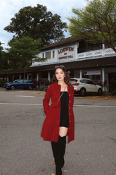 a lady in a black mini dress and a red tweed coat